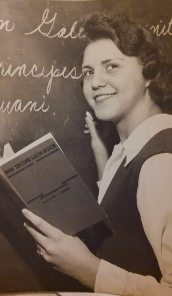 A young Grandma standing at a chalkboard teaching a lesson.